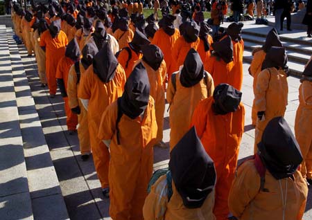 Protesters dressed as prisoners from the U.S. detention facility at Guantanamo Bay stand at the steps of a federal courthouse in Washington, January 11, 2007. 