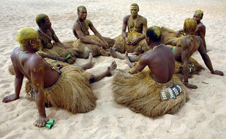 Voodoo practitioners sit in a circle during the Voodoo Day celebrations in Ouidah January 10, 2007. Thousands of people from all over Benin gather in Ouidah, a former slave port on the Atlantic Ocean, 40 km (25 miles) from Cotonou, Benin's capital city, revered as the cradle of voodoo and offer prayers and sacrifices to their gods. About 60% of the country's 6.3 million people practice voodoo. Picture taken January 10, 2007.