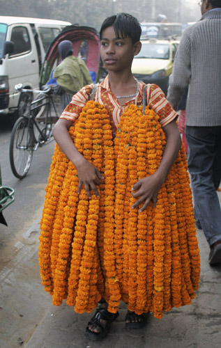  boy carries garlands of flowers for sale in the Bangladeshi capital Dhaka January 16, 2007. 