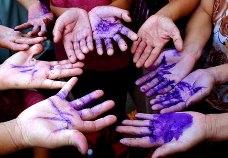 Students show their hands smeared with a kind of medical liquid after being rescued from a company in Ningbo, East China's Zhejiang Province in August 2006. Some 100 elementary students from Anhui and Henan provinces traded work-for-study in a company in Ningbo, where they were forced to work overtime and were confined at the company. Local police rescued all the students after receiving a report from four girls who ran away from the company.
