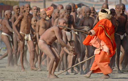 A Sadhu uses his baton to control Naga Sadhus on the banks of river Ganges during Ardh Kumbh Mela, or Half Pitcher festival in Allahabad January 16, 2007.