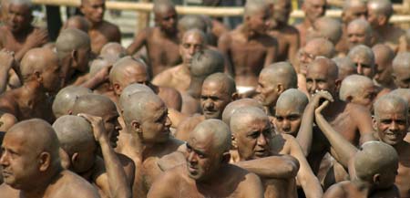 Naga Sadhus (holymen) wait on the banks of river Ganges during Ardh Kumbh Mela, Half Pitcher festival, in Allahabad January 16, 2007. Families from across India travel to Allahabad, at the confluence of the Ganges, the Yamuna and a mythical third river, the Saraswati, to bathe and and free themselves from the earthly cycle of reincarnation.