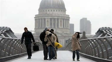 A group of people cross the Millennium Bridge battered by the strong winds in London Thursday, Jan 18, 2007. Heavy rain and high winds are expected to bring chaos to parts of Britain Thursday Jan 18, as the country gears up for a severe storm. The storms will be followed next week by plunging temperatures, snow and widespread frosts, forecasters said. (AP Photo/Alastair Grant) 