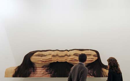 Visitors look at an artwork at Madrid's international contemporary art fair ARCO February 14, 2007. This year's edition features the participation of 250 galleries from 30 countries with South Korea being this year's invited country. 