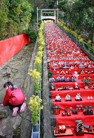 A girl plays near 400 dolls, known as Hina in Japan, displayed for the upcoming Japanese Doll Festival slated for March 3, in Katuura city, Chiba, east of Tokyo, Saturday, February 25, 2007. March 3 is a day to pray for young girl's growth and happiness. It is also called Peach Festival. 