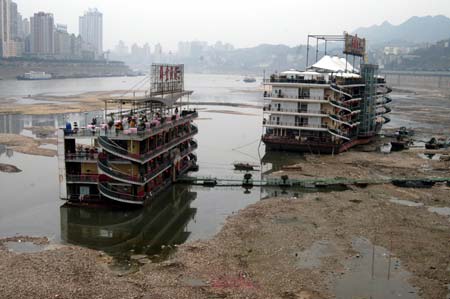 A general view shows two ships are stranded in the Jialing River, a branch of the Yangtze River, in Southwest China's Chongqing Municipality, February 26, 2007. Falling water levels in the Yangtze River have left at least 1.5 million people in Chongqing with water shortages, local authorities said. [newsphoto]