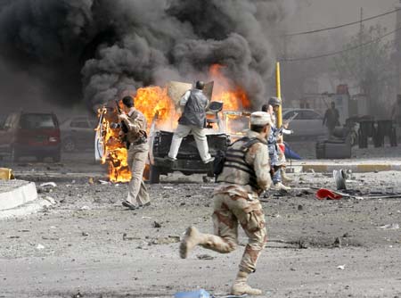 Iraqi soldiers secure the scene of a car bomb attack in Baghdad March 15, 2007. A car bomb targeting a joint Iraqi army and police checkpoint exploded in central Baghdad on Thursday, causing an unknown number of casualties, police said. 