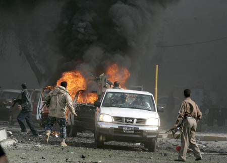 Cars burn at the scene of a car bomb attack in Baghdad March 15, 2007. A car bomb targeting a joint Iraqi army and police checkpoint exploded in central Baghdad on Thursday, causing an unknown number of casualties, police said. 