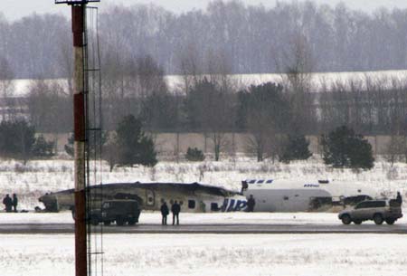 Rescue personnel stand near the wreckage of a Tu-134 aircraft that crashed upon landing at the airport in the central Russian city of Samara March 17, 2007. Seven people died and at least 10 were injured when the aircraft with 57 people aboard crash-landed in Samara on Saturday in heavy fog, Russian officials said. 
