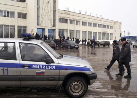 Police walk in front of the airport where a Tu-134 aircraft crashed upon landing in the central Russian city of Samara March 17, 2007. Seven people died and at least 10 were injured when the aircraft with 57 people aboard crash-landed in Samara on Saturday in heavy fog, Russian officials said. 