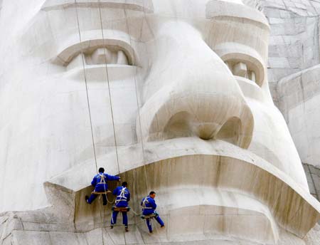 Chinese workers clean the statue of Emperors Yan and Huang in Zhengzhou, Central China's Henan Province, March 23, 2007. The statue is 106 meters high, with the eye three meters wide and the nose eight meters long. Emperors Yan and Huang, two emperors in ancient Chinese legends, are said to be the earliest ancestors of the Chinese nation. [newsphoto]