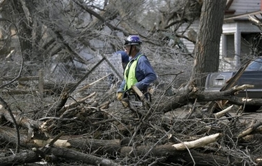 A clean-up crew works to cut fallen trees that were ripped from the ground and broken in half due to the powerful tornado that heavily damaged large sections of Holly, Colo., Thursday, March 28, 2007. The tornado killed one person, injured at least seven others and leaft dozens of cattle dead or dying, authorities said Thursday.