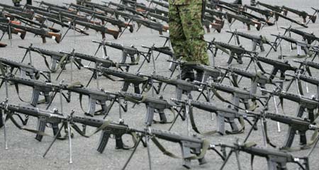 A Japan's Ground Self Defense Force (JGSDF) soldier stands among rows of weapons before a ceremony to mark the launch of the Central Readiness Force at the JGSDF's Asaka Base, north of Tokyo, March 31, 2007.