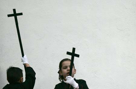 Young penitents wait to start the procession of the 'Pontificia, Real e Ilustre Cofradia de Ntra. Sra de las Angustias' brotherhood during Holy Week in Ferrol, northern Spain, April 4, 2007. Hundreds of Easter processions take place in Spain during Holy Week around the clock drawing thousands of visitors. 
