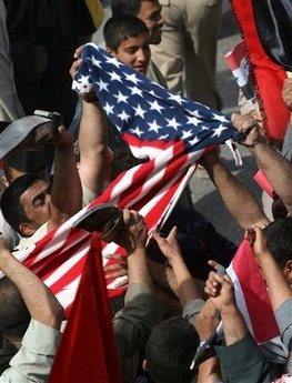 Followers of radical anti-US cleric Muqtada al-Sadr tear up an American flag the holy city of Najaf, Iraq, Monday, April 9, 2007, on the fourth anniversary of the fall of Baghdad to the US forces. Tens of thousands draped themselves in Iraqi flags and marched through the streets of two Shiite holy cities Najaf and Kufa in a rally that was called for by al-Sadr who issued a statement ordering his militiamen to redouble their battle to oust American forces and argued that Iraq's army and police should join him in defeating 'your archenemy.' (AP Photo/Hadi Mizban) 