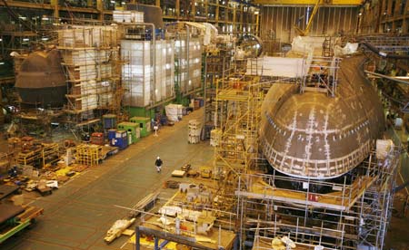 A worker walks between the first two Astute class nuclear submarines as they are built in the Devonshire Dock hall at the BAE systems facility in Barrow-in-Furness, northern England, May 8, 2007. The first of Britain's new class of nuclear submarines is expected to be launched in June 2007 and enter into active service late in 2008.
