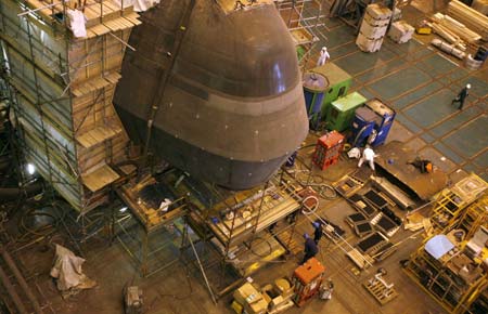 Men work beneath the bow of one of the the first two Astute class nuclear submarines as they are built in the Devonshire Dock hall at the BAE systems facility in Barrow-in-Furness, northern England, May 8, 2007. The first of Britain's new class of nuclear submarines is expected to be launched in June 2007 and enter into active service late in 2008. 