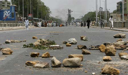 Protesters block a street during demonstrations in Karachi May 13, 2007. A Pakistani opposition supporter was killed in Karachi on Sunday during a protest against violence the previous day in which 34 people were killed in clashes between pro-government and opposition activists.