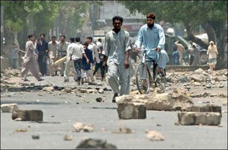 Pakistani residents walk along a rubble strewn street in Karachi.