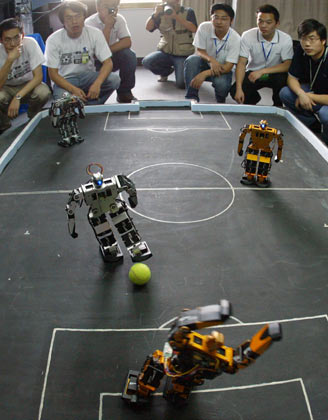 Students and designers for the Harbin Institute of Technology Robot Soccer Team watch a match in Wuhan, Central China's Hubei Province, May 14, 2007. The 8th National Robot Soccer Competition recently kicked off in the city, attracting 86 teams from across the country. The winners will represent China at the Federation of International Robot-soccer Association World Cup in San Francisco on June 13. [newsphoto]