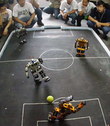 Students and designers for the Harbin Institute of Technology Robot Soccer Team watch a match in Wuhan, Central China's Hubei Province, May 14, 2007. The 8th National Robot Soccer Competition recently kicked off in the city, attracting 86 teams from across the country. The winners will represent China at the Federation of International Robot-soccer Association World Cup in San Francisco on June 13. [newsphoto]