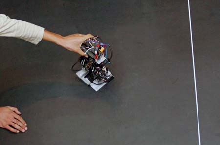 An unidentified man places a robot during the 8th National Robot Soccer Competition in Wuhan, Central China's Hubei Province, May 14, 2007.[newsphoto]