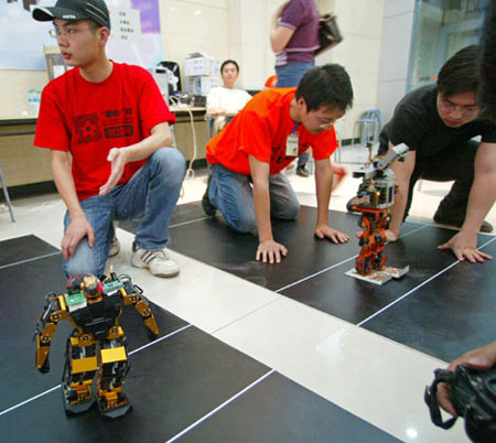 Students and designers for the Harbin Institute of Technology Robot Soccer Team watch a match in Wuhan, Central China's Hubei Province, May 14, 2007. The 8th National Robot Soccer Competition recently kicked off in the city, attracting 86 teams from across the country. The winners will represent China at the Federation of International Robot-soccer Association World Cup in San Francisco on June 13. [newsphoto]