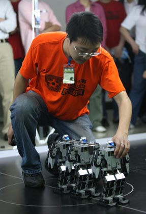 A member from Wuhan Institute of Technology team arranges robots during during the 8th National Robot Soccer Competition in Wuhan, Central China's Hubei Province, May 15, 2007.The winners will represent China at the Federation of International Robot-soccer Association World Cup in San Francisco on June 13. [newsphoto]