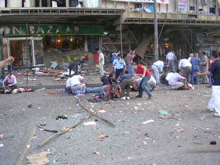 Police and residents help injured people lying on the street after an explosion rocked a shopping mall in Ankara May 22, 2007. A powerful bomb outside a crowded shopping mall in the heart of Turkey's capital Ankara killed five people and injured at least 60 on Tuesday, Prime Minister Tayyip Erdogan said.