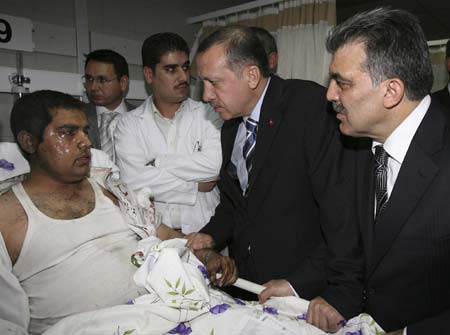 Turkey's Prime Minister Tayyip Erdogan (C) and Foreign Minister Abdullah Gul (R) visit an injured man in a hospital in Ankara May 22, 2007. A bomb outside a crowded shopping mall in Turkey's capital Ankara killed five people and injured at least 60 people on Tuesday, Erdogan said.