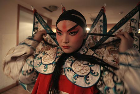 A performer wears his costume before a Sichuan Opera show at the Jingjiang Theatre in Chengdu, southwest China's Sichuan province May 25, 2007. Sichuan Opera, which is distinguished by the face-changing technique where performers change masks in quick succession with a wave of the hand or by turning around, is one of the oldest forms of Chinese opera. 