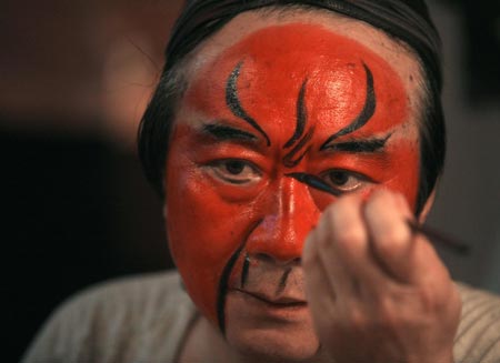A performer puts on make-up prior to a Sichuan Opera show at the Jingjiang Theatre in Chengdu, southwest China's Sichuan province May 25, 2007. Sichuan Opera, which is distinguished by the face-changing technique where performers change masks in quick succession with a wave of the hand or by turning around, is one of the oldest forms of Chinese opera. 