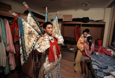 A performer puts on his costume prior to a Sichuan Opera show at the Jingjiang Theatre in Chengdu, southwest China's Sichuan province May 25, 2007. Sichuan Opera, which is distinguished by the face-changing technique where performers change masks in quick succession with a wave of the hand or by turning around, is one of the oldest forms of Chinese opera. 