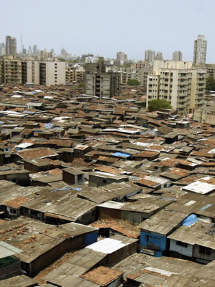 High-rise buildings stand next to Dharavi, Asia's largest slum area, in Mumbai May 30, 2007. Authorities in India's financial capital invited a global tender on Wednesday to tear down Asia's biggest slum and replace it with gleaming new apartments, but the project is suspect in the eyes of most of it inhabitants. 