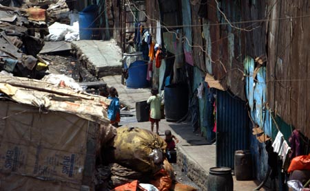 Children play outside their houses in Dharavi, Asia's largest slum area, in Mumbai May 30, 2007. Authorities in India's financial capital invited a global tender on Wednesday to tear down Asia's biggest slum and replace it with gleaming new apartments, but the project is suspect in the eyes of most of it inhabitants. 