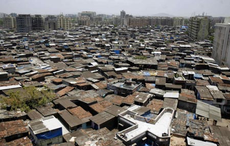 High-rise buildings stand next to Dharavi, Asia's largest slum area located in Mumbai May 30, 2007. Authorities in India's financial capital invited a global tender on Wednesday to tear down Asia's biggest slum and replace it with gleaming new apartments, but the project is suspect in the eyes of most of it inhabitants. The number of people living in slums in India, Asia's fourth largest economy, has more than doubled in the past two decades, the government said on Thursday.