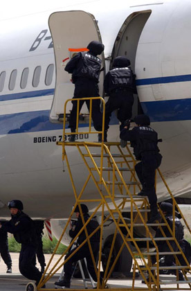 Chinese special policemen enter aircraft during an anti-hijacking drill at an airport in Hohhot, North China's Inner Mongolia Autonomous Region, May 31, 2007. China is looking to establish an anti-terrorism legal framework and authorities are busy drafting a law to better combat terror threats, China Daily reported.