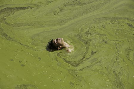 A boy swims in a pond on the outskirts of Jammu June 5, 2007. 