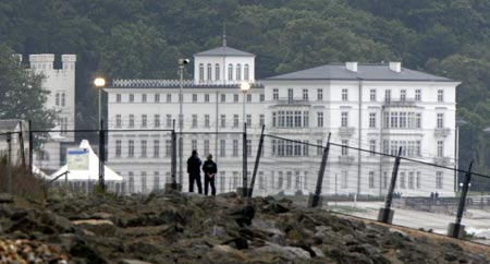 Visitors stand at the security fence in front of the venue for the upcoming G8 summit at the eastern German Baltic Sea resort of Heiligendamm June 3, 2007. German police clashed with hundreds of protesters in the port of Rostock on June 2, 2007 following a much larger peaceful demonstration against next week's Group of Eight summit in the nearby Baltic resort of Heiligendamm, injuring several hundreds of police officers, police said.
