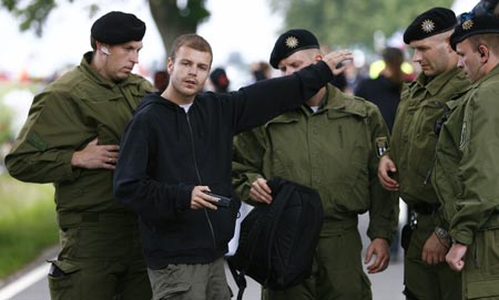 Police search demonstrators arriving at the perimeter of Rostock-Laage airport ahead of the arrival of U.S. President George W. Bush to the G8 Summit June 5, 2007.