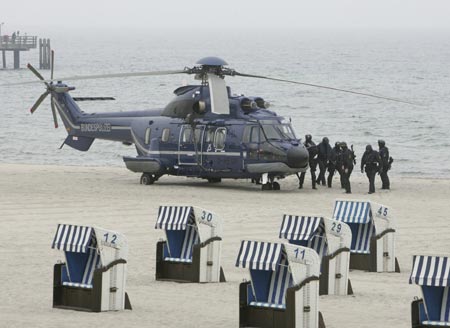 A German police special unit stands near a helicopter during an exercise ahead of the G8 summit on the beach in Kuehlungsborn June 5, 2007. Leaders from the world's major industrialised nations meet in the Baltic resort of Heiligendamm on June 6-8 for a Group of Eight (G8) summit. 