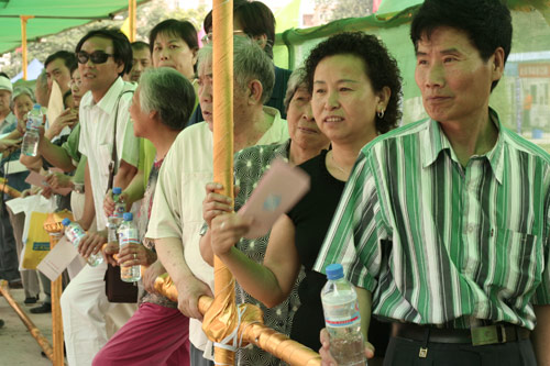 Residents wait to cast their votes on the demolishment and reconstruction of old buildings in Juixiaqiao Sub-district in Beijing, June 9, 2007. Local government and the real estate developer jointly organize the vote on Saturday to see if majority residents of over 5000 families accept the new compensation policy after failed attempts to reach an agreement through other ways. Both notary officials and supervisors are invited to monitor the vote that runs from 9 a.m. to 9 p.m. at six ballot booths. [Sun Yuqing/www.chinadaily.com.cn]