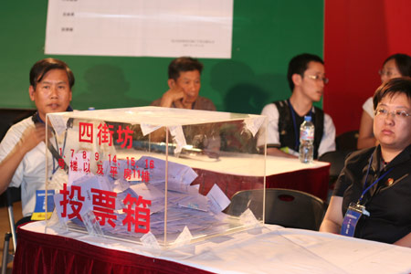 Notary officials and residents' representatives wait to count the votes after a voting on the housing demolition and compensation policy at Jiuxianqiao sub-district in Chaoyang District of Beijing, June 9, 2007. Some 3,711 families, about 57% of the 5,473 families, cast their votes on Saturday, with 2,451 votes for and 1,228 votes against the demolition and compensation plan. Thirty-two votes were invalid. 