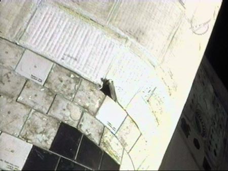 A torn insulation blanket (upper right) on the port side of the Shuttle Atlantis is shown in this video grab from the orbiter's end effector camera during a survey of the spacecraft's thermal protection system June 8, 2007. 