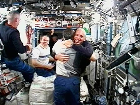 ISS Commander Fyodor N. Yurchikhin hugs Expedition 15/16 Flight Engineer Clayton C. Anderson (R) upon his arrival at the International Space Station in this view from NASA TV June 10, 2007. Flight engineer Oleg V. Kotov (2nd L) and Mission specialist Patrick Forrester (L) talk in the background in this view from the Destiny module. 