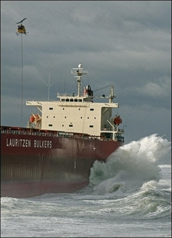 A helicopter lowers salvage equipment to the 'Pasha Bulker' which ran aground in wild seas near Newcastle. Rescue workers are urging thousands of people to evacuate their homes after deadly storms lashed Australia's east coast.(