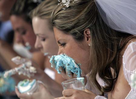 Contestants compete in the WE tv network's 'Bridezilla-Ultimate Cake Eating Contest' in New York's Times Square June 12, 2007. The cable channel gave away a $25,000 prize to kick off the fourth season of their 'Bridezillas' series. 