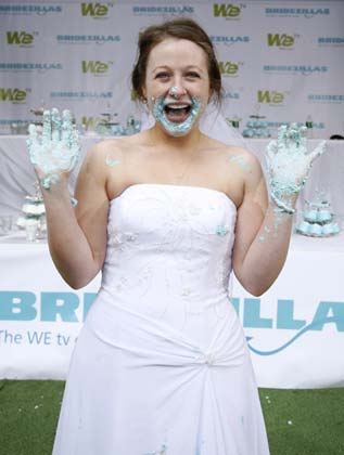 Stephanie Florio, 24, of Sayville, New York, holds her hands up in victory after she won WE tv's cake eating contest Take The Cake in Times Square in New York June 12, 2007. The cable channel gave away a $25,000 prize to kick off the fourth season of their 'Bridezillas' series.