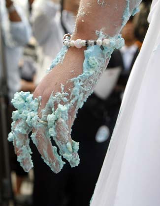 The cake-covered hand of Stephanie Florio is seen after she won the WE tv network's 'Bridezilla-Ultimate Cake Eating Contest' in New York's Times Square June 12, 2007. The cable channel gave away a $25,000 prize to kick off the fourth season of their 'Bridezillas' series.