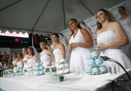 Contestants prepare to compete in the WE tv network's 'Bridezilla-Ultimate Cake Eating Contest' in New York's Times Square June 12, 2007. The cable channel gave away a $25,000 prize to kick off the fourth season of their 'Bridezillas' series. 